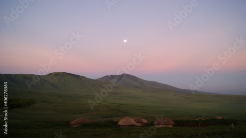 Early morning moon over a Maasai village. East Africa.