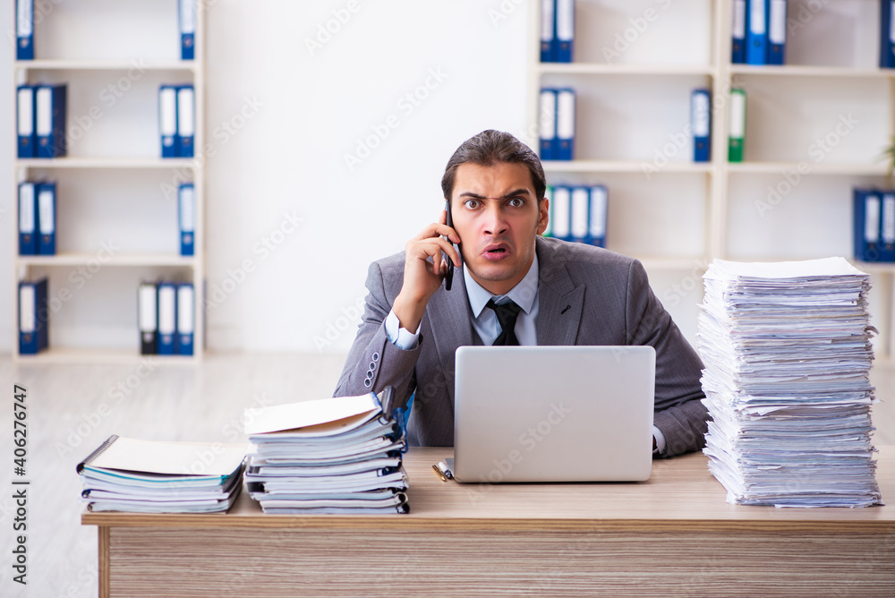 Young male employee unhappy with excessive work Young male employee unhappy with excessive work