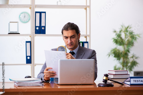 Young male lawyer sitting in the office