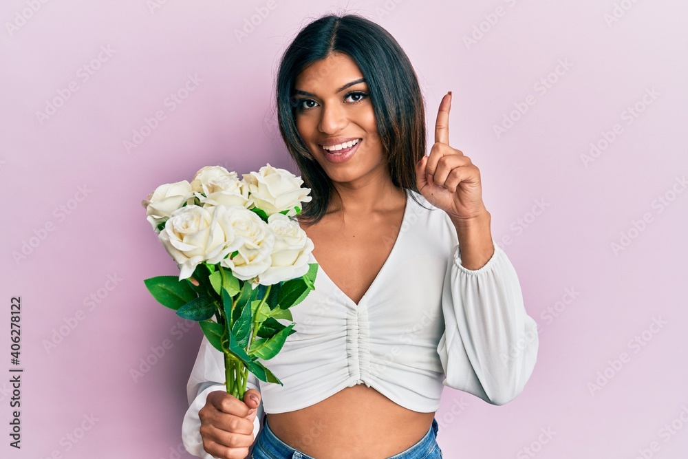 Young latin transsexual transgender woman holding flowers smiling with an idea or question pointing finger with happy face, number one Young latin transsexual transgender woman holding flowers smiling with an idea or question pointing finger with happy face, number one