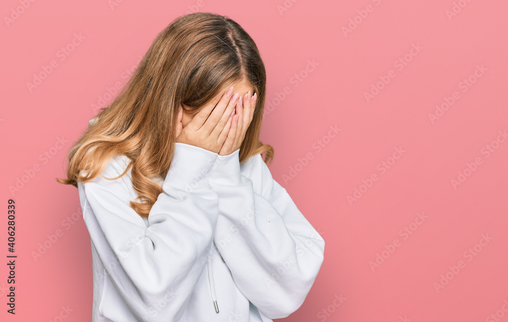 Beautiful young caucasian girl wearing casual sweatshirt with sad expression covering face with hands while crying. depression concept. Beautiful young caucasian girl wearing casual sweatshirt with sad expression covering face with hands while crying. depression concept.