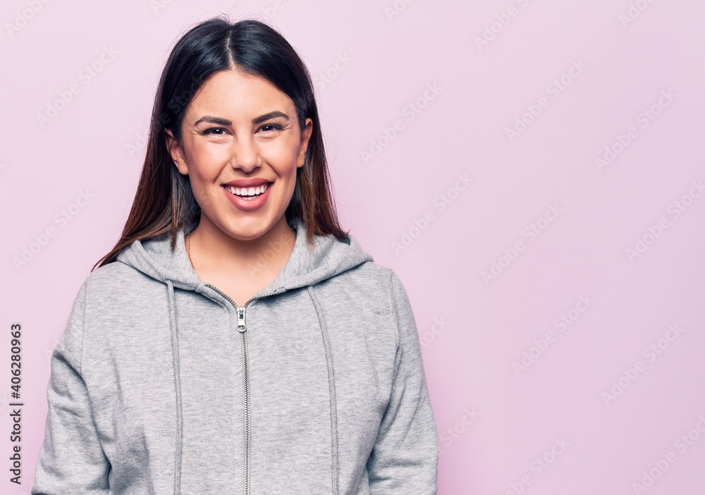Fototapeta premium Young beautiful sporty woman wearing sportswear standing over isolated pink background with a happy and cool smile on face. Lucky person.