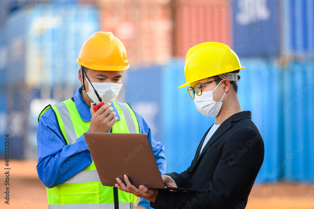 Engineer or Foreman Talk to an Asian businessperson about loading containers from a cargo ship. Engineer or Foreman Talk to an Asian businessperson about loading containers from a cargo ship.