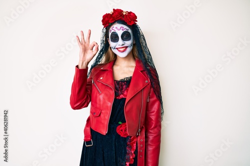 Woman wearing day of the dead costume over white smiling positive doing ok sign with hand and fingers. successful expression.