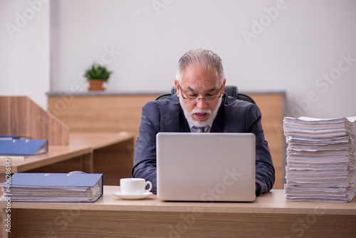 Old male employee working in the office © Elnur
