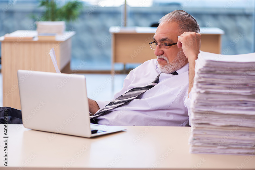 Aged businessman employee unhappy with excessive work Aged businessman employee unhappy with excessive work
