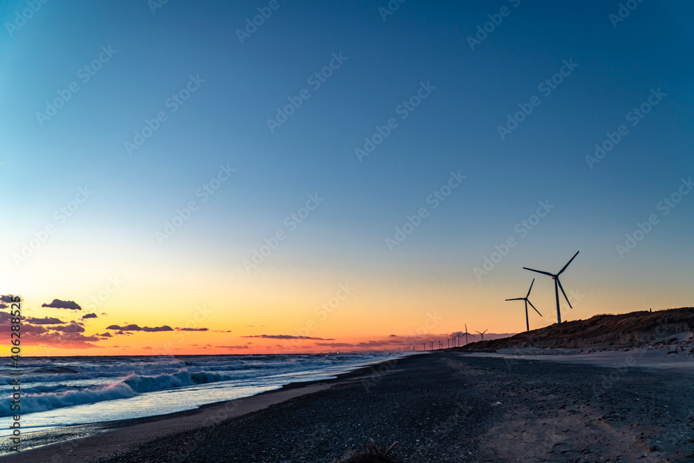   静岡県御前崎市の浜岡砂丘・海沿い浜辺の日没時の風力発電機群