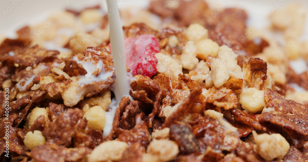 Pour milk into the cereal Pour milk into the cereal