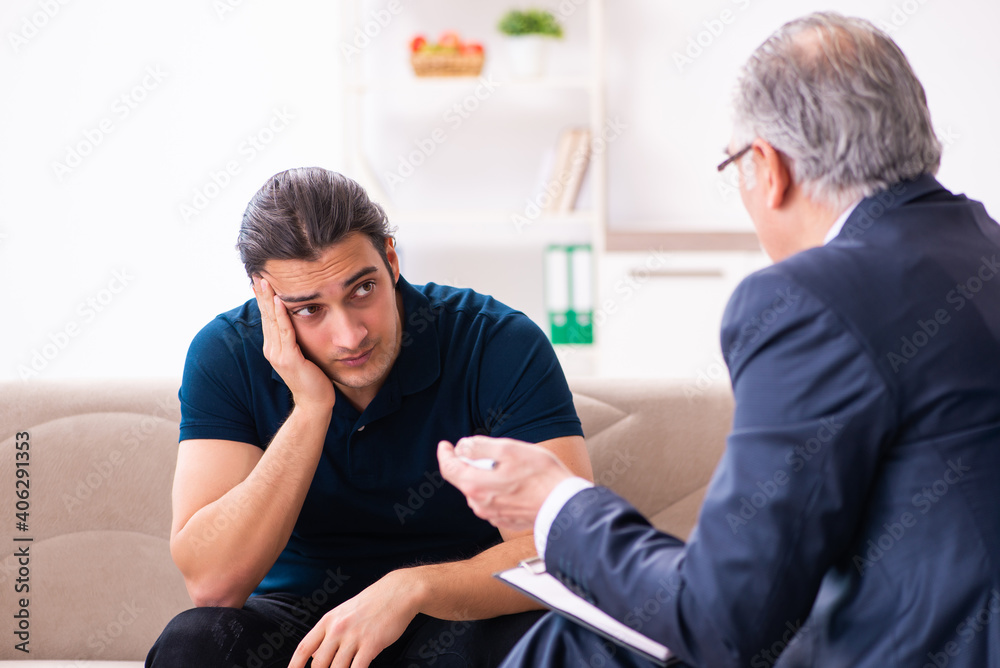 Young man visiting old male psychologist Young man visiting old male psychologist