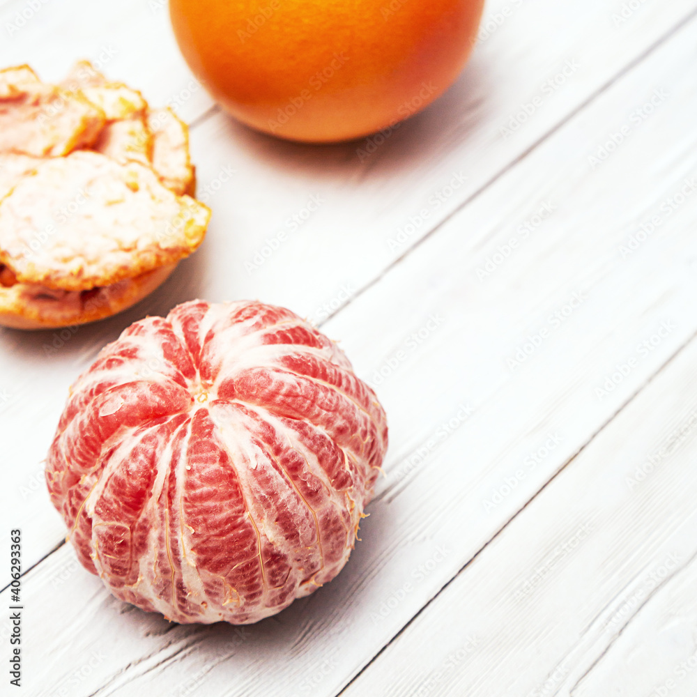 Grapefruit whole and peeled. Minimalistic flat lay on a light background with copy space. Healthy food concept Grapefruit whole and peeled. Minimalistic flat lay on a light background with copy space. Healthy food concept