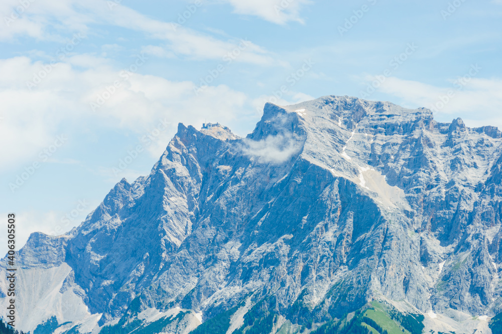 Die Zugspitze inklusive Berg Station von der Tiroler Seite aus gesehen an einem bewölkten schönen Sommertag