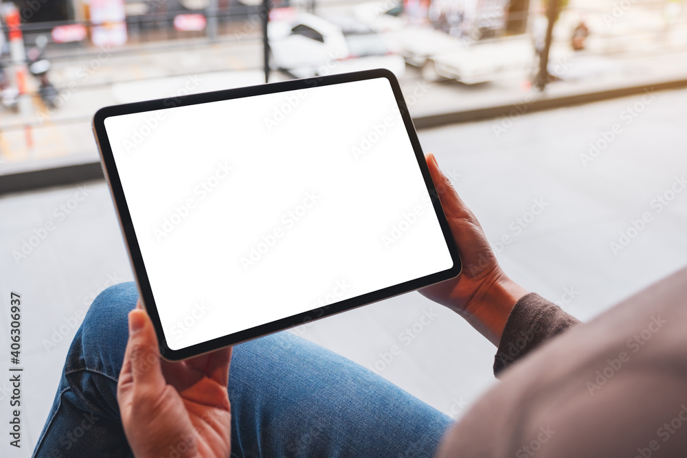 Mockup image of a woman holding digital tablet with blank white desktop screen