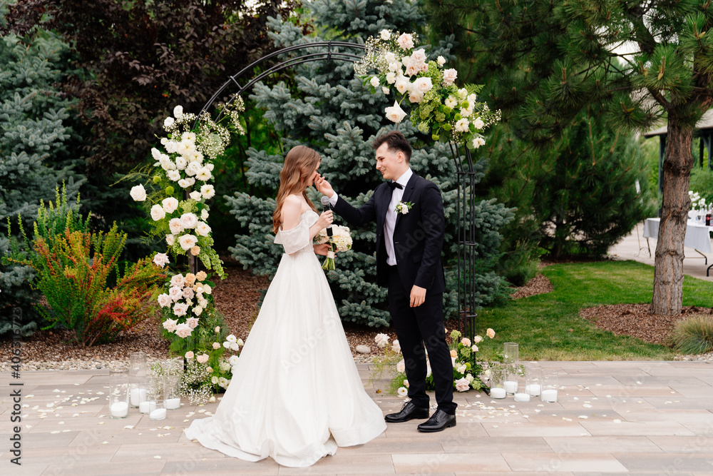 wedding ceremony in arch of living flowers. bride says wedding vow and cry wedding ceremony in arch of living flowers. bride says wedding vow and cry