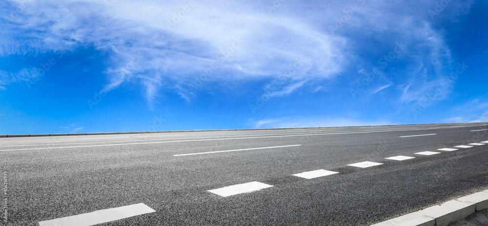 Fototapeta premium Empty asphalt road and blue sky with white clouds.Road background.