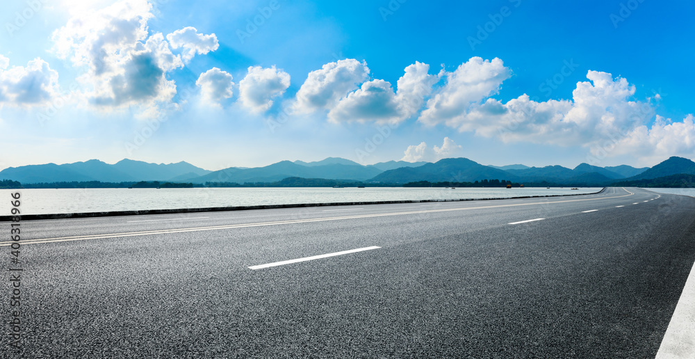 Fototapeta premium Empty asphalt road and blue sky with white clouds.Road background.