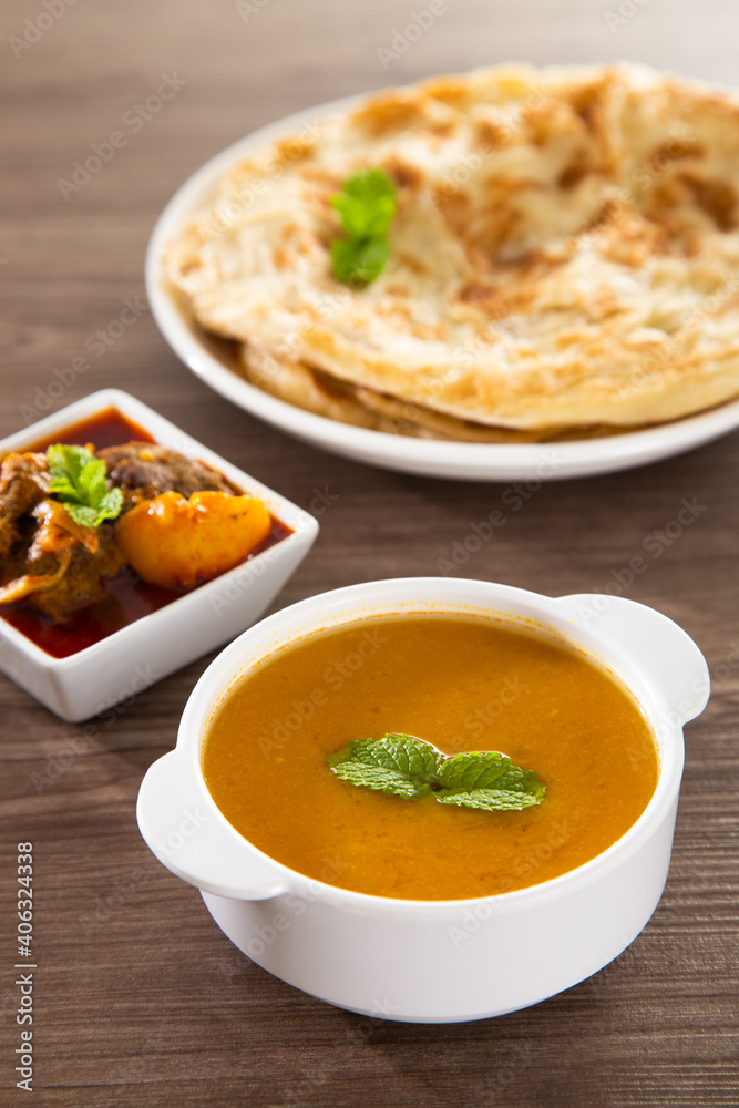 Roti Parata or Roti canai with lamb curry sauce. Roti Parata or Roti canai with lamb curry sauce.