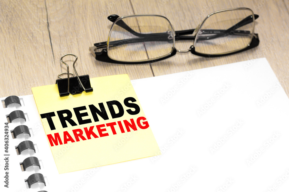Text TREND MARKETING on a notepad with eyeglasses and text documents. Could be for business, financial and marketing concepts Text TREND MARKETING on a notepad with eyeglasses and text documents. Could be for business, financial and marketing concepts