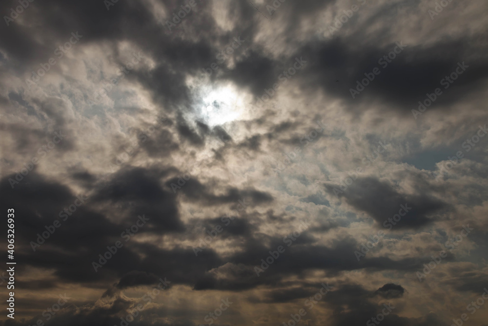 Clouds in dramatic sky. Black, gray clouds In sun sky. Background nature. Texture cumulus floating on blue sky. Environment, atmosphere. Place for banner, site an inscription text or logo. Copy space