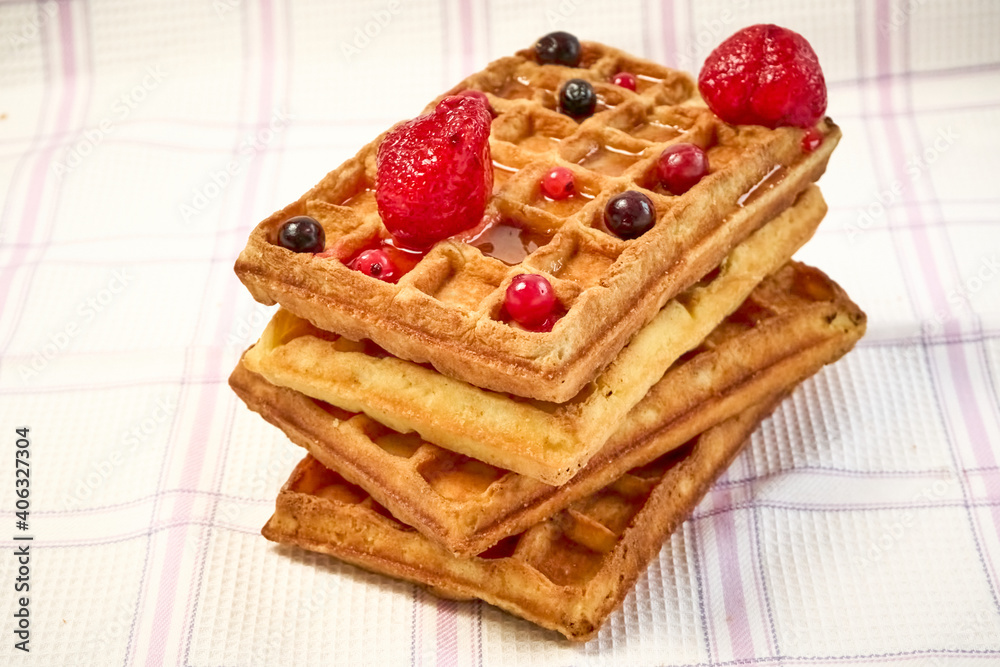 Belgian waffles with berries on a fabric background. Belgian waffles with berries on a fabric background.