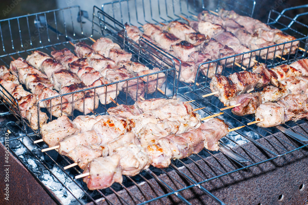 pieces of meat strung on skewers are grilled on coals