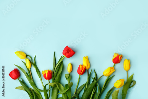 Yellow red tulip flowers bouquet on blue background, copy space. Banner for seasonal holiday, springtime concept, International Woman day 8 march, Happy Easter greeting flyer, invitation, traditional