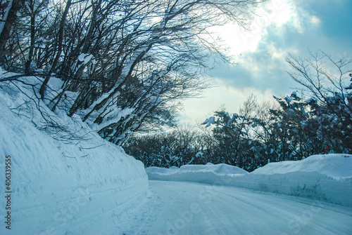 山の雪の踏み固めた道路を車で走る光景