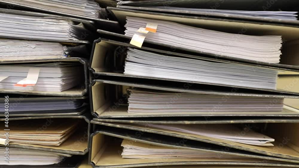 Close-up old files and papers of big folders in archives of business financial documents.