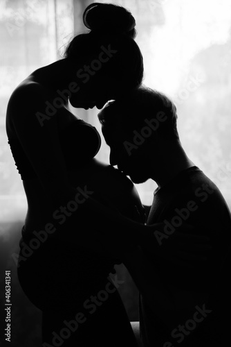 Multi ethnic couple married and in love in silhouette by the window