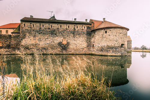 Massive and well fortified medieval Water Castle of Svihov is situated in the Pilsen Region, Czech Republic, Europe. There are water canal around the stone castle. Winter view. photo