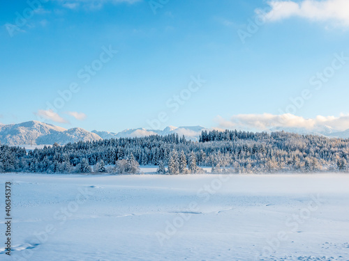 Winter landscape with mountains lake and fog