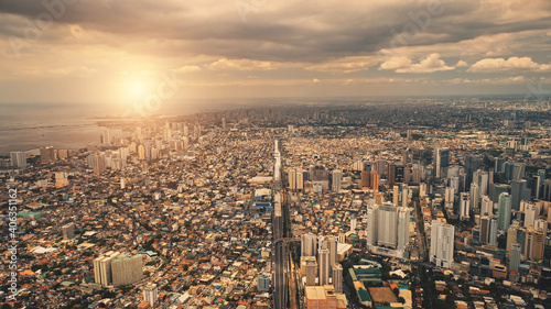 Sun cityscape of port town Manila aerial. Sunrise light over modern buildings, skyscrapers of downtown streets. Metropolis city of Manila, Philippines, Asia. Cinematic summer soft drone shot