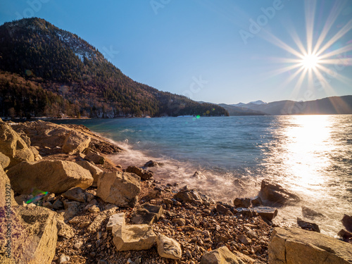 Walchensee as one of beautiest Bavarian lakes during sunrise phase with warm blue sky scenery
