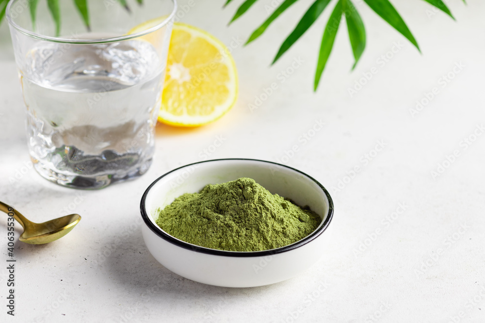 Green superfood powder for making healthy energy drink. Powder mix from wheat grass, barley grass, chlorella, spirulina, maca, matcha. White background. close-up Green superfood powder for making healthy energy drink. Powder mix from wheat grass, barley grass, chlorella, spirulina, maca, matcha. White background. close-up