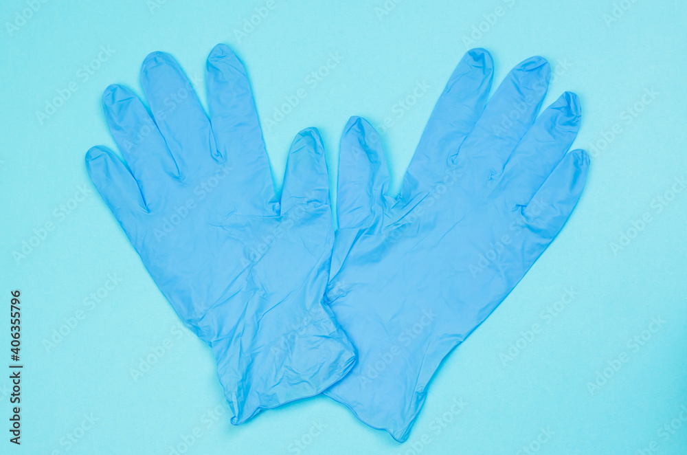 Fototapeta premium Blue medical gloves on a light blue background