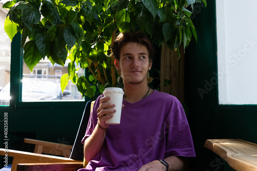 guy prepares a drink in a paper cup. young man is drinking tea.