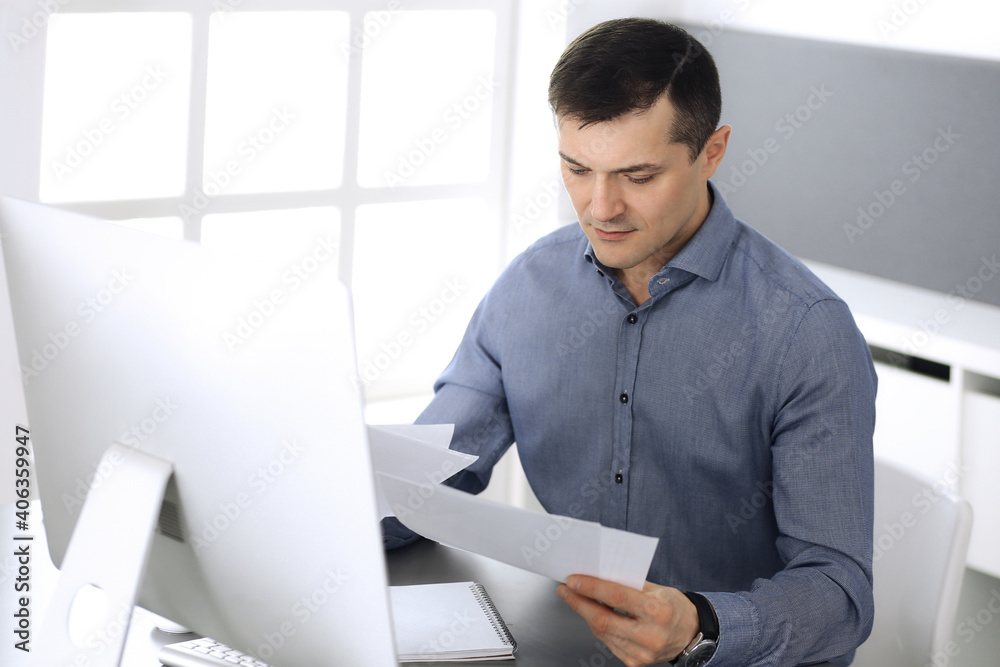 Businessman working with computer in modern office. Headshot of male entrepreneur or company director at workplace. Business concept Businessman working with computer in modern office. Headshot of male entrepreneur or company director at workplace. Business concept