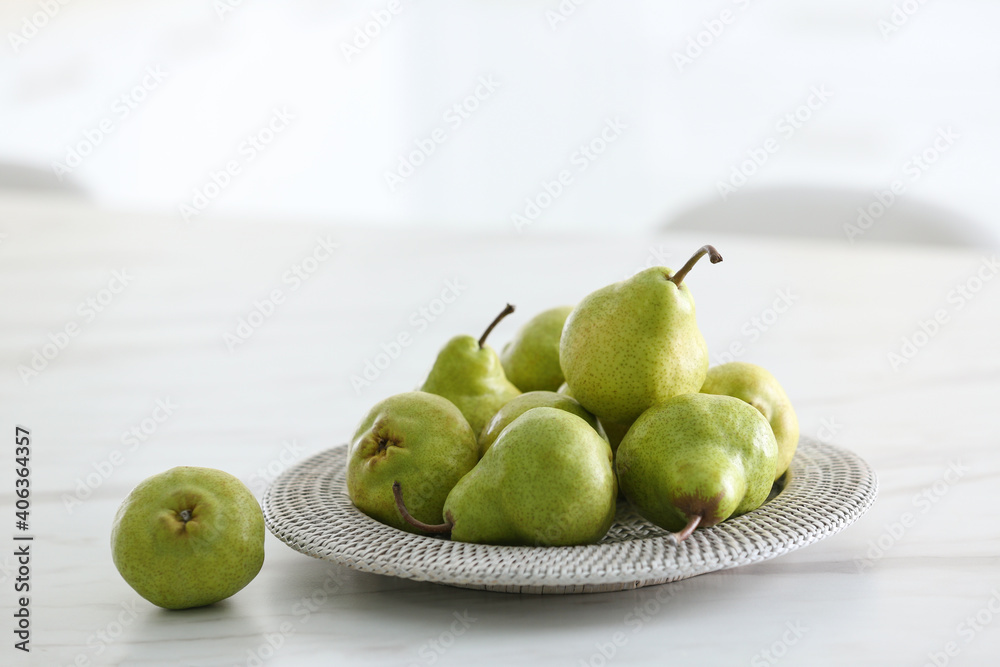 Plate with fresh ripe pears on white table Plate with fresh ripe pears on white table