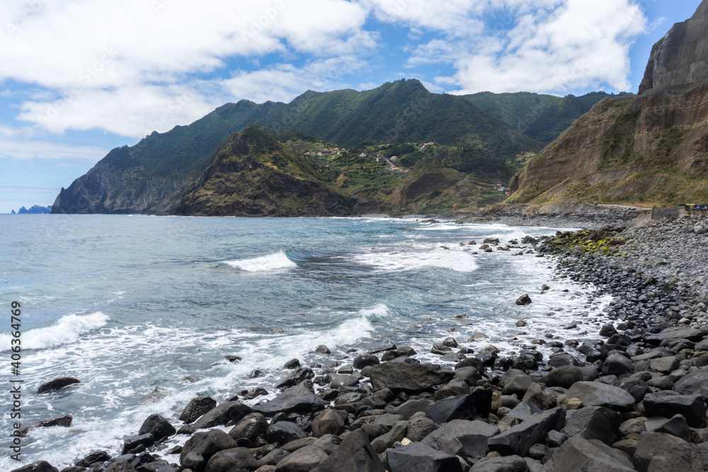 Stoney beach with high cliffs falling into the sea, Madeira Island