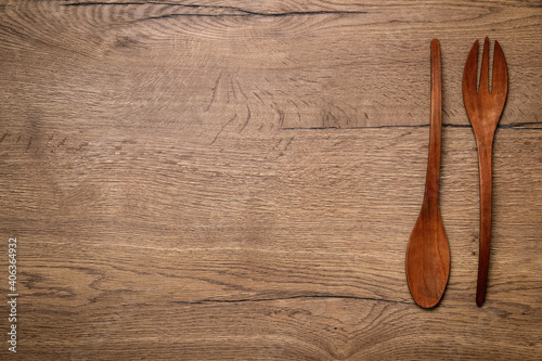 Wooden spoon and fork on table, flat lay with space for text. Cooking utensils
