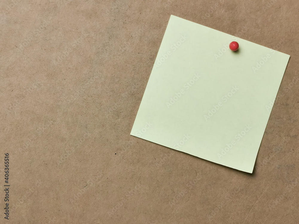 Yellow paper note with pin board over brown background.Copy space. Yellow paper note with pin board over brown background.Copy space.
