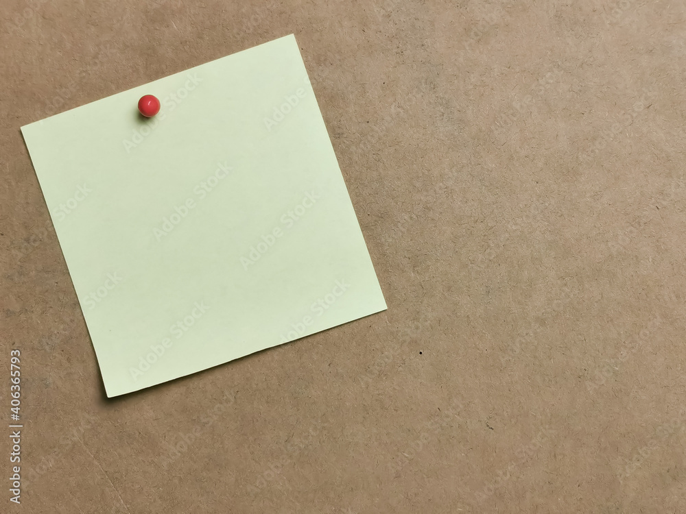 Yellow paper note with pin board over brown background.Copy space. Yellow paper note with pin board over brown background.Copy space.