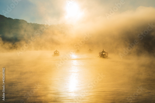 Lake view misty morning of reservoir around with soft mist with yellow sun light in the sky background, sunrise at Ban Rak Thai, Mae Hong Son, northern of Thailand. ,bluerred image © pong0402
