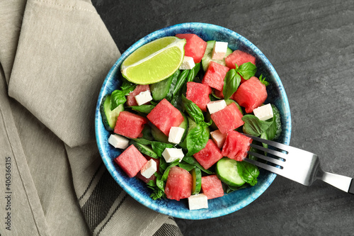 Delicious salad with watermelon served on black table, flat lay