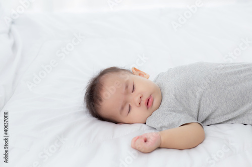 Portrait of asian little baby girl sleeping on bed in the bedroom at home, newborn napping with cozy and relax, infant innocence in bedtime, happy toddler cute, growth of child and emotion, indoors.