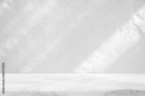 Leinwand Poster Marble Table with White Stucco Wall Texture Background with Light Beam and Shadow, Suitable for Product Presentation Backdrop, Display, and Mock up