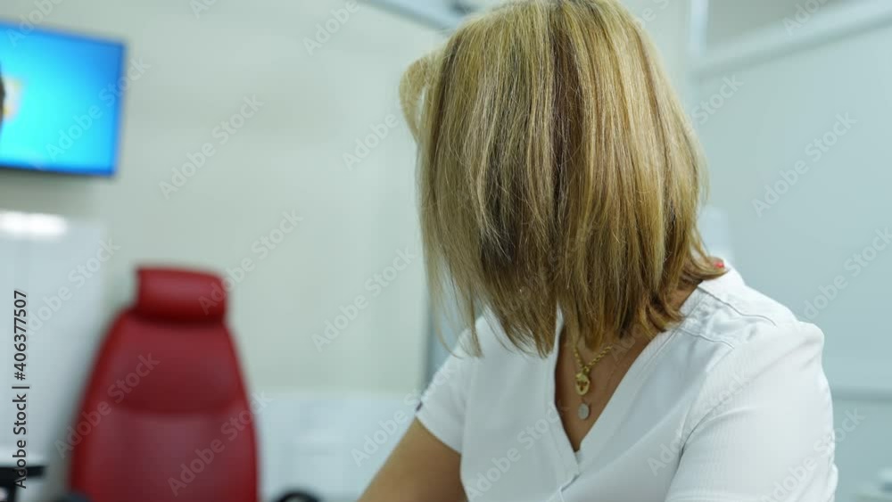 Female doctor in medical center. Woman ophthalmologist in white coat sitting in the cabinet and talking to a patient. Female doctor in medical center. Woman ophthalmologist in white coat sitting in the cabinet and talking to a patient.