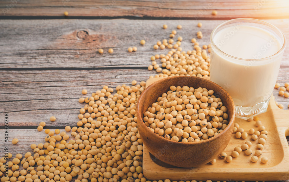 Soybeans in brown wooden bowl with Soy milk on wooden table background.Healthy food Concept. Soybeans in brown wooden bowl with Soy milk on wooden table background.Healthy food Concept.