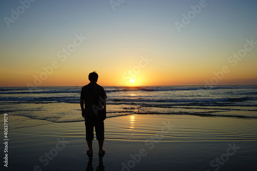 Man standing on Nusa Dua Beach at dusk, Beautiful sunset, Bali island, Indonesia