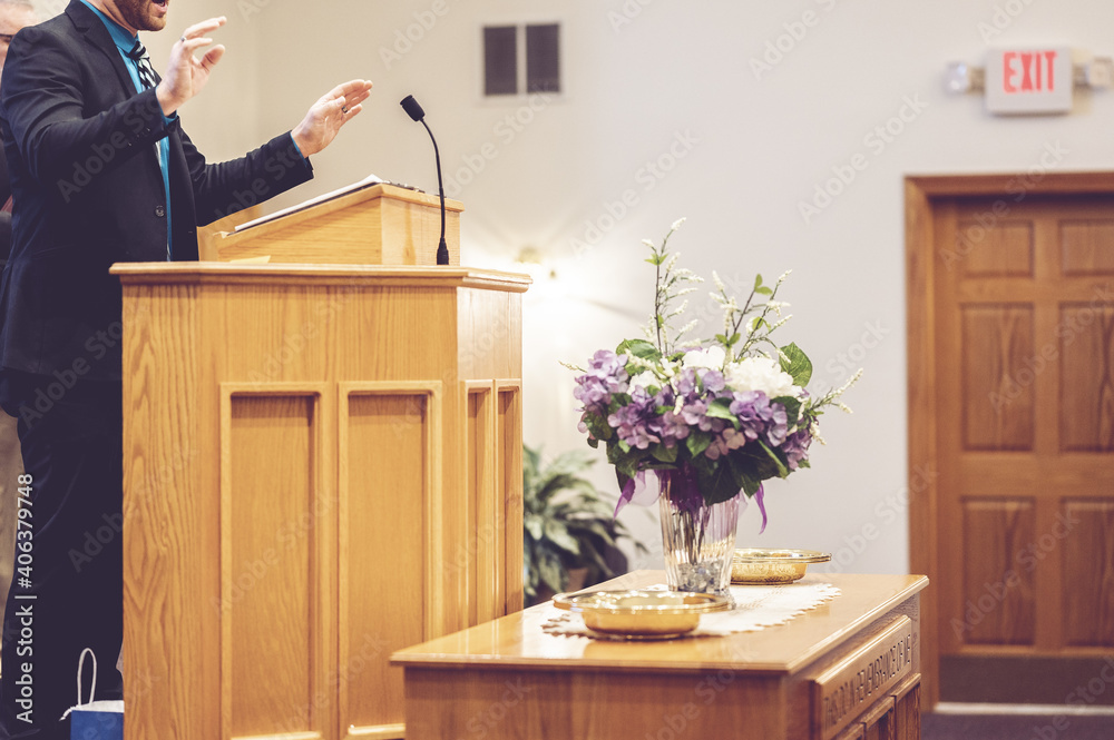 View of a pastor preaching on the pulpit in the church - obrazy, fototapety, plakaty 
