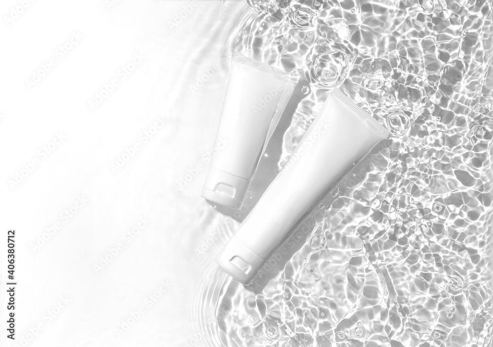 White cosmetic tubes on the water surface. Summer water pool fresh concept. Flat lay, top view. White cosmetic tubes on the water surface. Summer water pool fresh concept. Flat lay, top view.